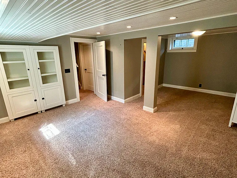 Lower-level secret bookcase doors offer extra storage. A large living room with connected space allows for a private suite or large family room.