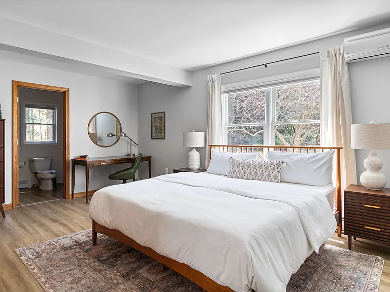 Primary bedroom with king bed, workspace, full bathroom, and two closets
