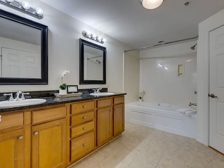 Primary bedroom Bath featuring double sinks, lots of cabinets, & a huge soaking tub.