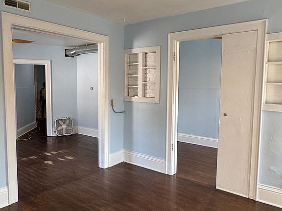 Living room looking into the dining room off to the left, bedroom to the right. Beautiful original hardwood floors throughout.