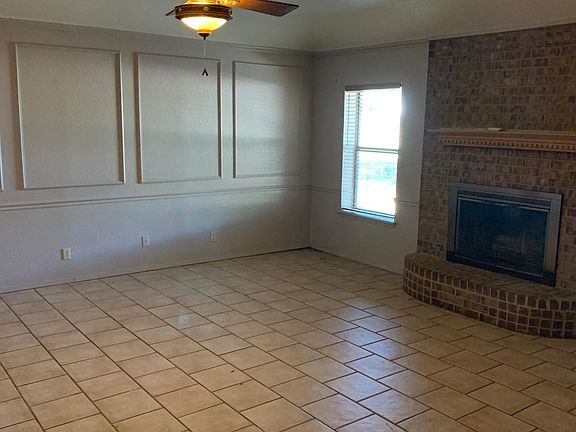 This is the family room, complete with fireplace, tiled floors, two windows.