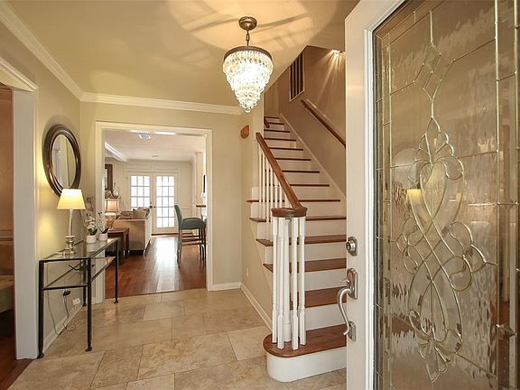 QUALITY ABOUNDS: From the leaded glass entry door to the travertine flooring, it's easy to see as you enter the house that thoughtful upgrades have all been done with quality in mind. You'll find crown molding throughout the home, as well as real har