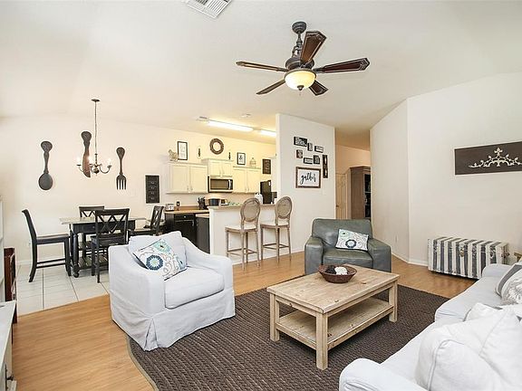 This light and bright spacious living room is the perfect layout for entertaining or just relaxing! Whether it's simply a night in or entertaining family and friends! Featuring dark stained ceiling fan, large windows with blinds, high ceilings, and a
