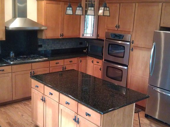 Custom kitchen with new backsplash, double oven, stainless steel, & granite