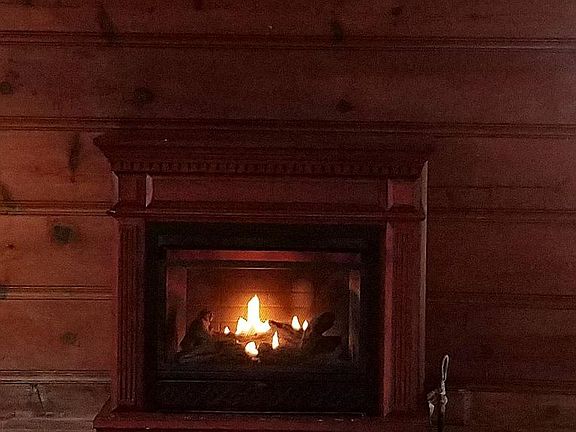 Gas fireplace with fan and thermostat, secondary heat source, flooring is waterproof Smartcore laminate.
