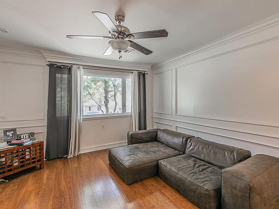 Living room featuring ceiling fan, hardwood / wood-style floors, and crown molding