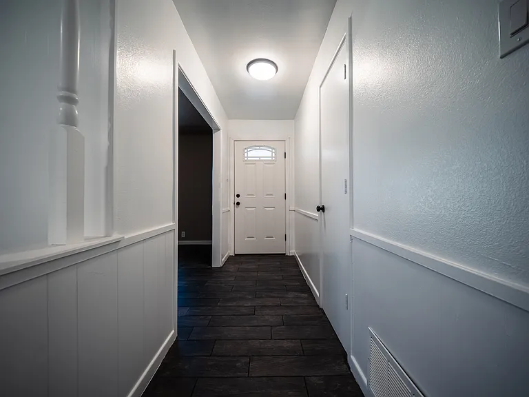 Hallway with recessed lighting and dark hardwood floors throughout