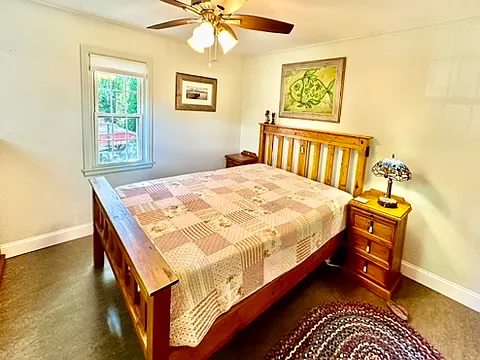 This queen bedroom has plenty of natural light that shines in from two windows.