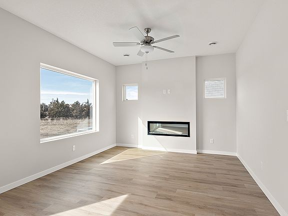 The family room is spacious with a ceiling fan.,