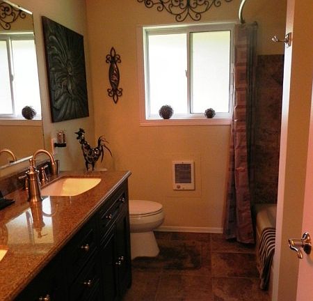The recently remodeled main level bath includes a double sink vanity with granite counter, tile floor and tile tub surround. There is also a linen closet for storage.