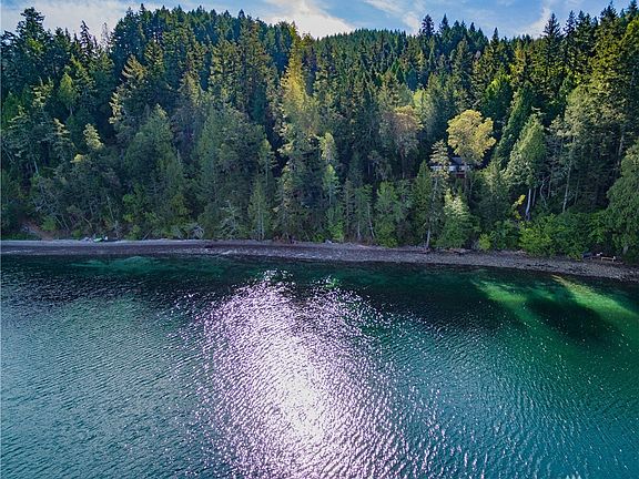 Pea gravel beach with wilderness view along the saltwater shoreline.