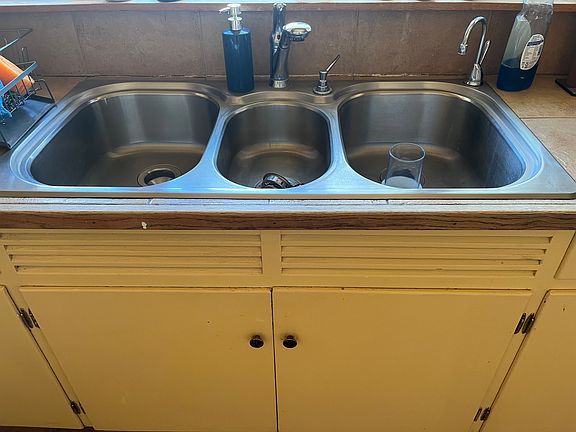 large three basin sink in kitchen.