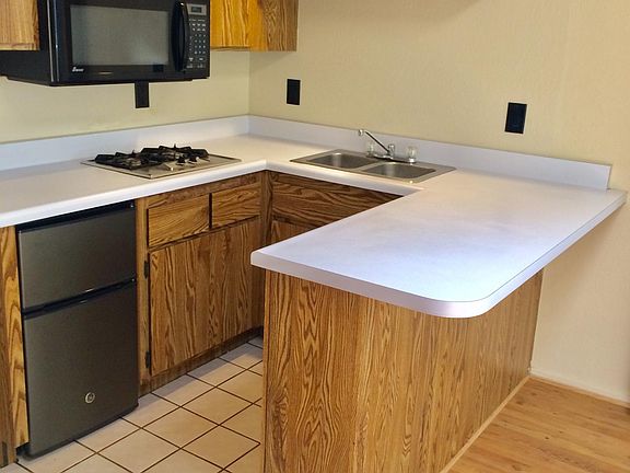 Similar photo of unit kitchen. Actual kitchen has upgraded sink faucet, new 2-burner gas stove and new microwave with vent fan underneath for stove.