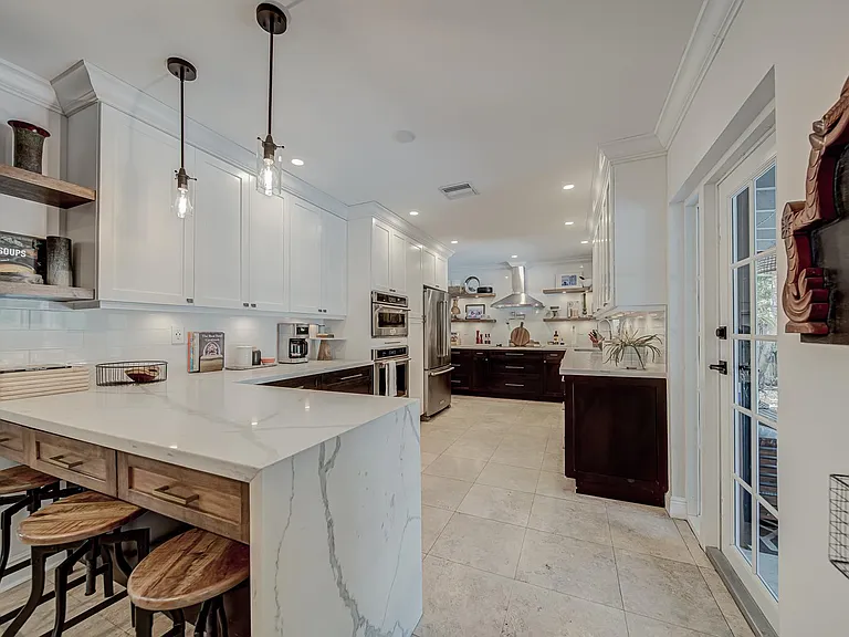 View of the kitchen from the front living room. Peninsula has a quartz waterfall countertop.