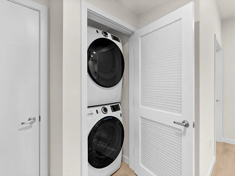 In-home stacked washer and dryer tucked behind folding closet doors. In-home stacked washer and dryer tucked behind folding closet doors.