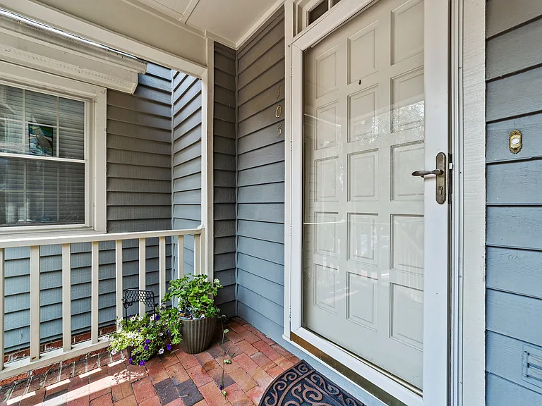 Covered front porch with brick entry, transom window, and welcoming curb appeal.