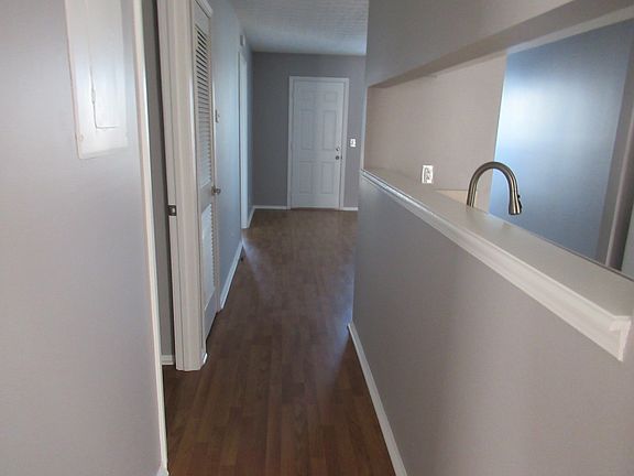 Hallway with view of cutout into the kitchen