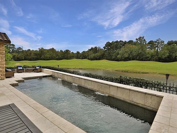 The resort-like pool features waterfalls, a view of the lake and golf course, and no back neighbors.
