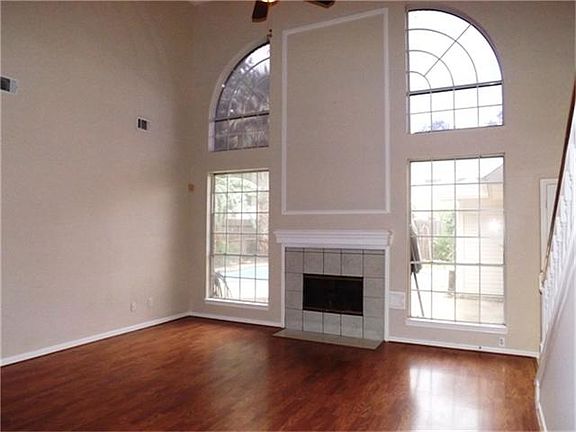 Spacious downstairs living room offers light-filled windows overlooking the backyard and pool
