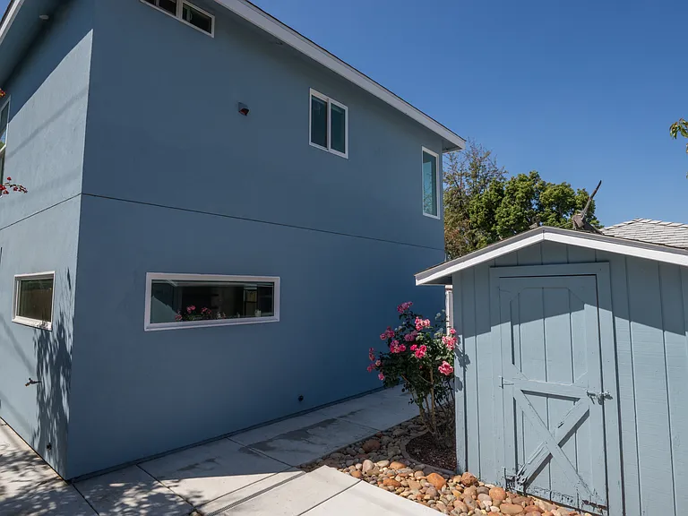 Side of house with storage shed.