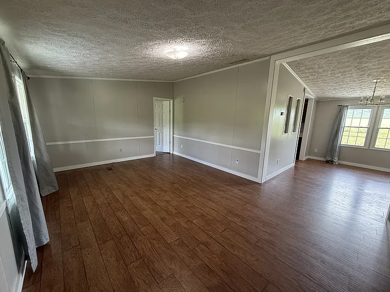 Living Area with view of primary bedroom entrance and the dining area
