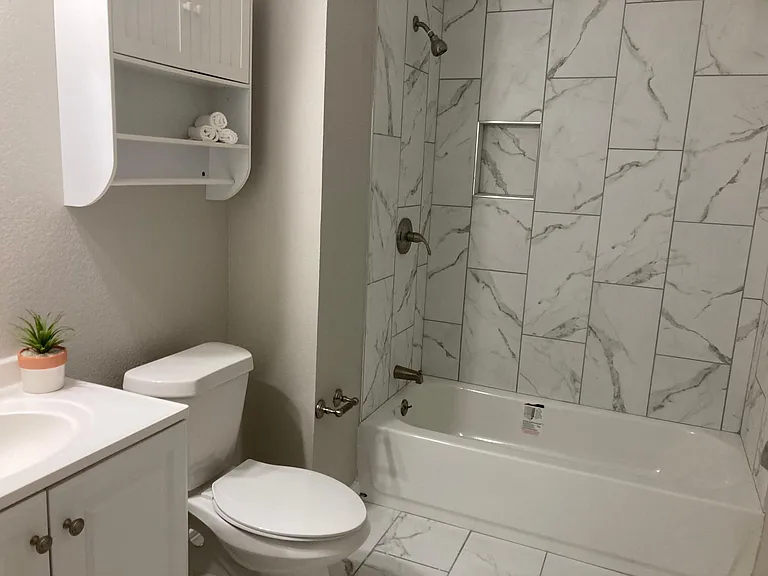 Bathroom 2
Marbled bath area with tub and shower.
