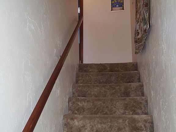 Stairs to upstairs (full bath, 2 bedrooms, linen closet). (Note: furnishings belong to a prior tenant; unit will be rented unfurnished)