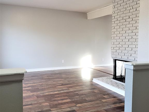 Spacious living room with beautiful laminate floor and see through fireplace