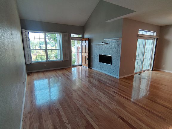 Living room with vaulted ceiling, dining area with patio access