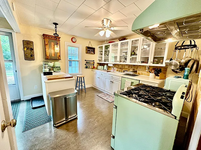 A large and spacious kitchen with a gas stove, range hood, all the mod cons and new marmoleum floor.