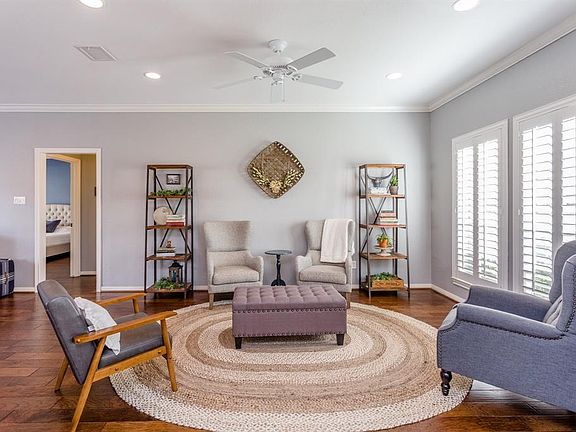 The family room is quite large and offers two seating areas. The area shown is at the front of the house and boasts crown molding and large windows with plantation shutters that offer views of the pretty front lawn.