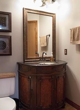 Upper level full bath with ceramic tile, updated lighting & custom vanity.