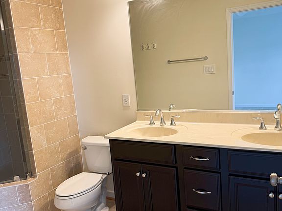Primary bathroom with double vanity and large mirror