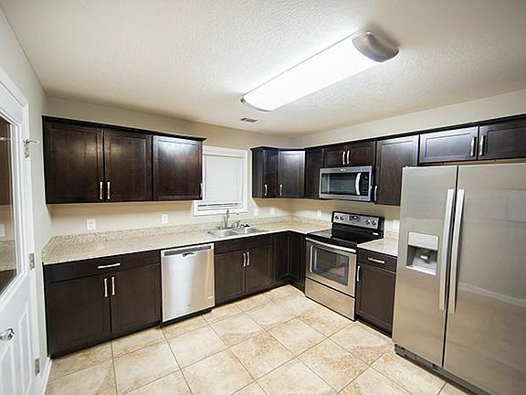 Open kitchen with stainless appliances, granite counter tops and tile flooring
