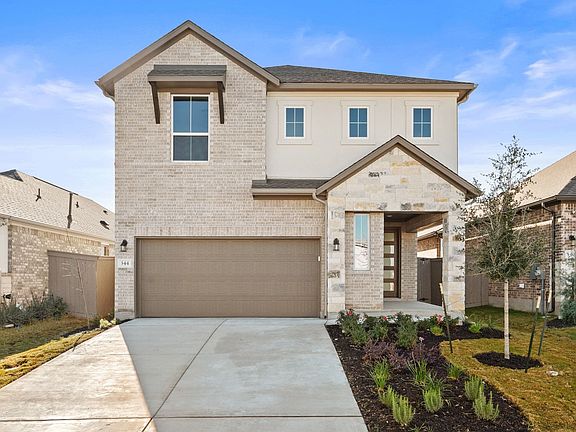 A two-story residential house with a garage, surrounded by a well-maintained lawn and landscaping, s