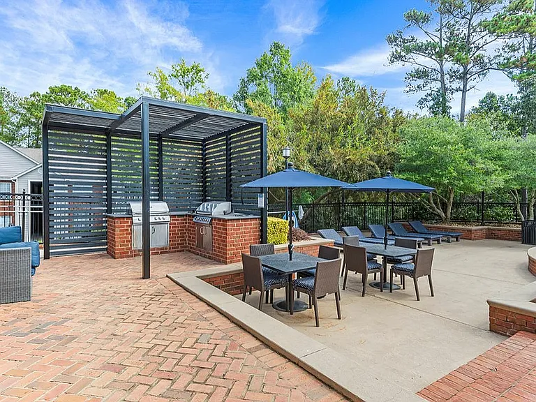 Pool Lounge Chairs and BBQ Area at Retreat at Peachtree Apartments