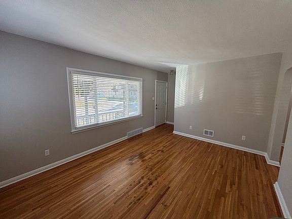 Living room with new blinds, new floor, paint and lighting.