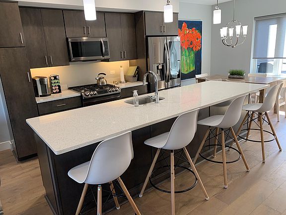 The fully-equipped kitchen is anchored by a massive, quartz center island with seating for 4.