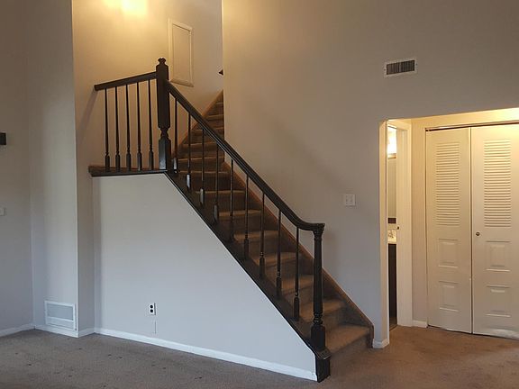 The living room view from the window. Steps that go up to the 3rd floor where the bedrooms are located. The kitchen is all the way to the left.
