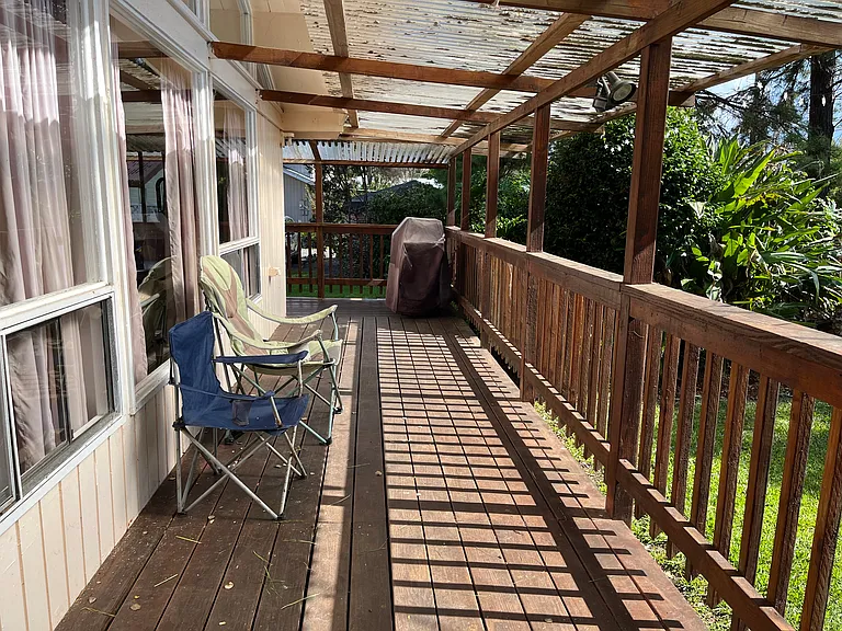 Front deck with barbecue, looks out to front yard. Proceed to the left of the grill to access side deck, side door, bonus shower, and side yard with greenhouse.