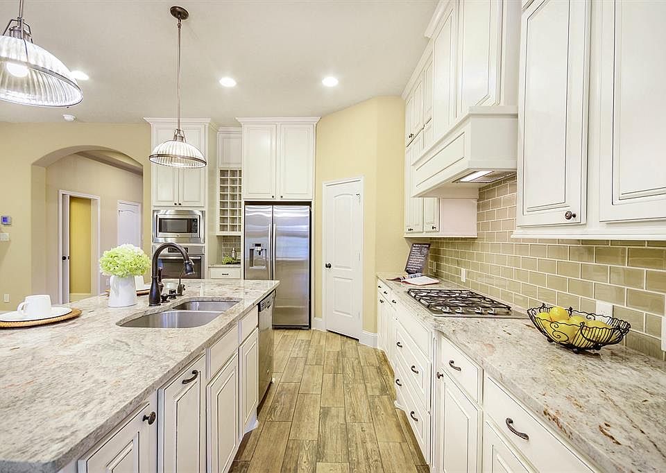 Stainless appliances, gas cooktop, stunning antique finish cabinetry with under mount lighting, upgraded granite countertops, built-in wine rack, subway tile backsplash...