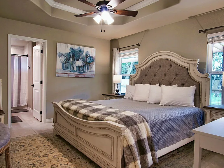 Spacious primary bedroom featuring a vaulted ceiling with ceiling fan, plus an attached bathroom and walk-in closet.