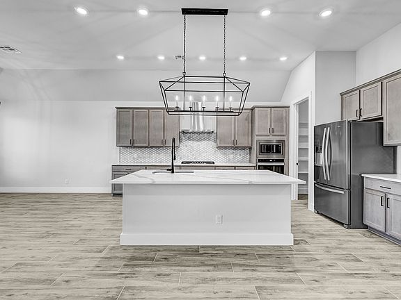 Designer kitchen with oversized cabinetry and stainless appliances.