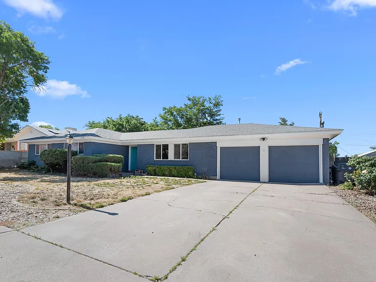 Single-story home with a wide driveway, two-car garage, and mature landscaping offering easy access and curb appeal.