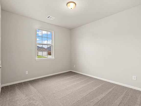 The secondary bedroom features plush carpet and neutral paint.