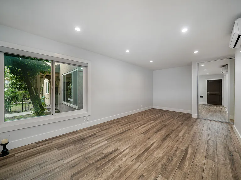 Unit 9 studio with view courtyard, black out shade, laminate hardwood floor, recessed ceiling light & mirrored wardrobe closet & split ac & heat.