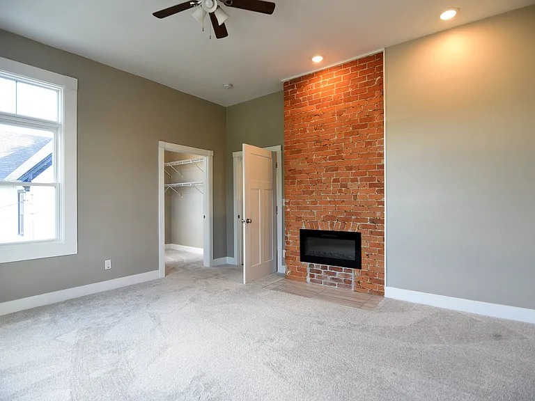 Huge, bedroom #2 boasting a stunning restored original brick chimney with modern fireplace with remote controlled insert.