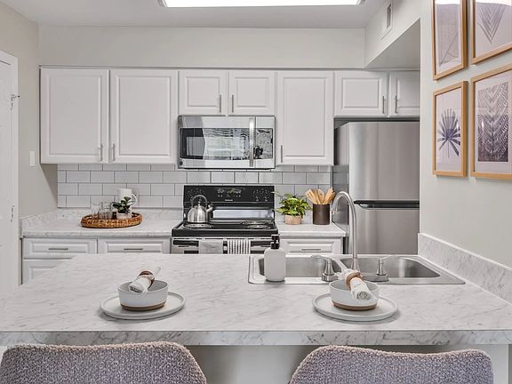 Experience elegance in our newly renovated kitchens with stunning white cabinetry, Carrara countertops, and a white subway tile backsplash, designed to inspire culinary enthusiasts.