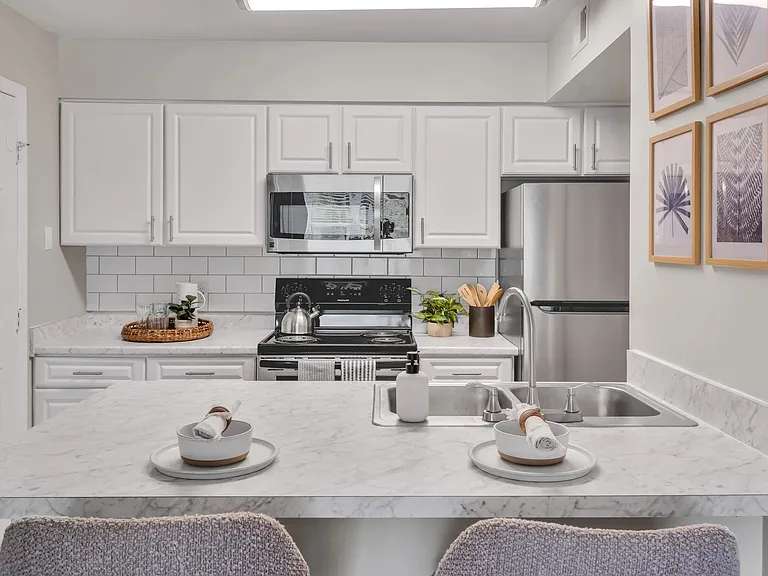 Experience elegance in our newly renovated kitchens with stunning white cabinetry, Carrara countertops, and a white subway tile backsplash, designed to inspire culinary enthusiasts.