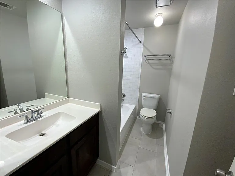 Bathroom vanity featuring a single basin sink and chrome faucet